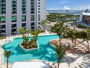 A hotel with a pool area, palm trees, and a view of the cityscape. - Bright & Breezy 1 Bed Unit With Water & City Views (Miami)