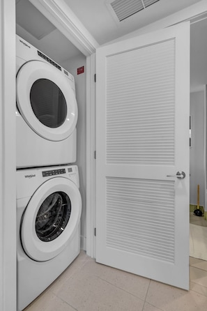 A laundry room with two Whirlpool washing machines and a closed door. - Bright & Breezy 1 Bed Unit With Water & City Views (Miami)