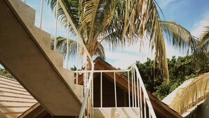 A staircase leading to a wooden deck with a view of palm trees and a clear sky. - Casa Boga - Comfortable designer house in La Punta (Brisas de Zicatela)