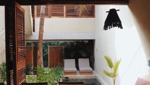 A modern living room with a pool, wooden furniture, and a view of the outdoor area. - Casa Boga - Comfortable designer house in La Punta (Brisas de Zicatela)
