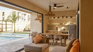 A modern living area with a pool, dining space, and kitchen.