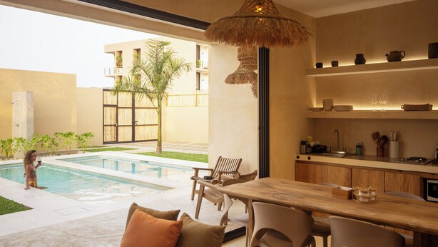 A modern kitchen with a dining area, a pool, and a view of a building with balconies.