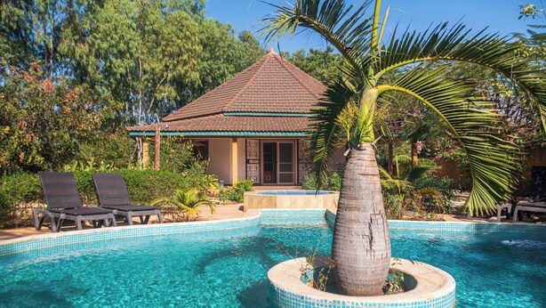 A pool with clear blue water, surrounded by lounge chairs and a palm tree. - 3-bedroom villa in gorgeous Ngaparou with WiFi, AC, 10 min. away from the beach (Ngaparou)