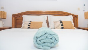 A neatly made bed with a wooden headboard, two white pillows, and a blue blanket rolled at the foot. - 3-bedroom villa in gorgeous Ngaparou with WiFi, AC, 10 min. away from the beach (Ngaparou)