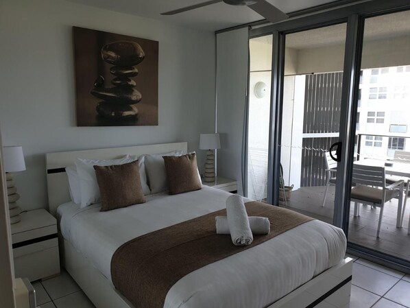 Habitación de hotel moderna con una cama grande, vistas al exterior y un cuadro en la pared.