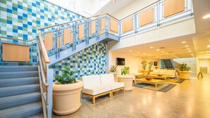 A spacious lobby with a checkered wall, a staircase, seating area, and potted plants. - New! 3Bd 2Bth Oceanfront / Pool / Boat /224b (Virginia Beach)