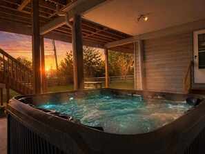 Ett bubbelbad utomhus, under en pergola av trä.