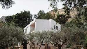 A modern white building with a staircase leading to an upper level, surrounded by olive trees and a stone wall. - Villa Rubino Guest house Mondello (Palermo)