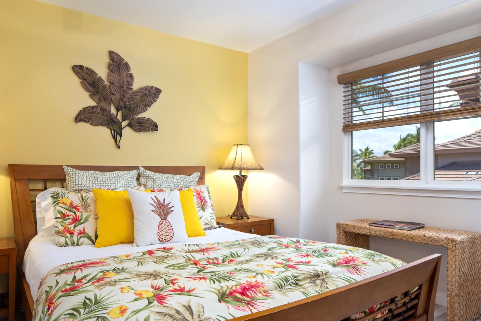 A hotel room with a bed, a nightstand, a lamp, a wall art piece, a window with blinds, and a small table with a magazine.