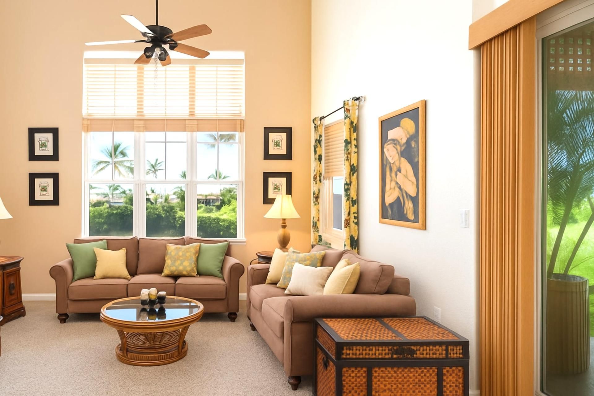 A living room with two sofas, a coffee table, a ceiling fan, and a window with blinds.