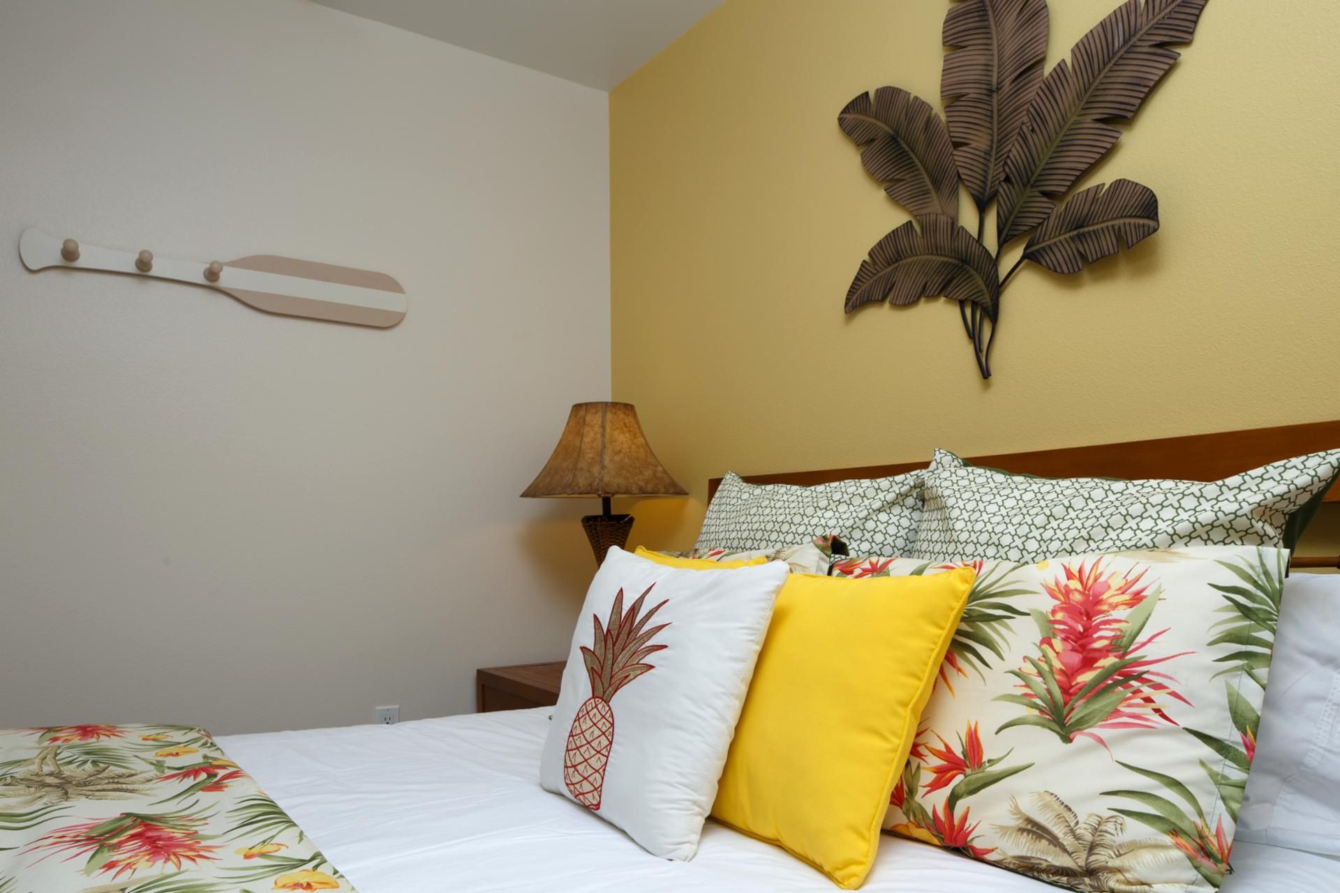 A hotel room with a bed, a nightstand, a lamp, and decorative wall art.