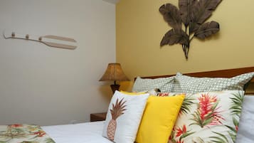 A hotel room with a bed, a nightstand, a lamp, and decorative wall art.