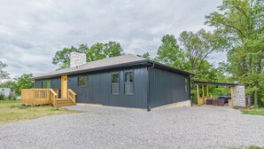A single-story building with a gravel driveway and a wooden deck. - Spacious 5-bedroom just 1 minute from Bennett Spring State Park! (Lebanon)