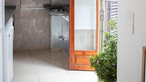 A compact kitchen with a built-in stove, white cabinets, and a wooden-framed door. - APARTMENTS THE MUSHROOMS. HISTORICAL CENTER (Sevilla)