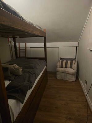 A small, narrow room with a bunk bed and a single chair. - Apartment with the best skiing in the South American Andes (la parva)