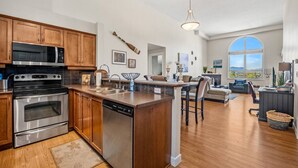 A modern kitchen with stainless steel appliances, wooden cabinets, and a large island with bar stools.