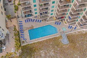 Uma área de piscina com espreguiçadeiras, piscina e escadaria.