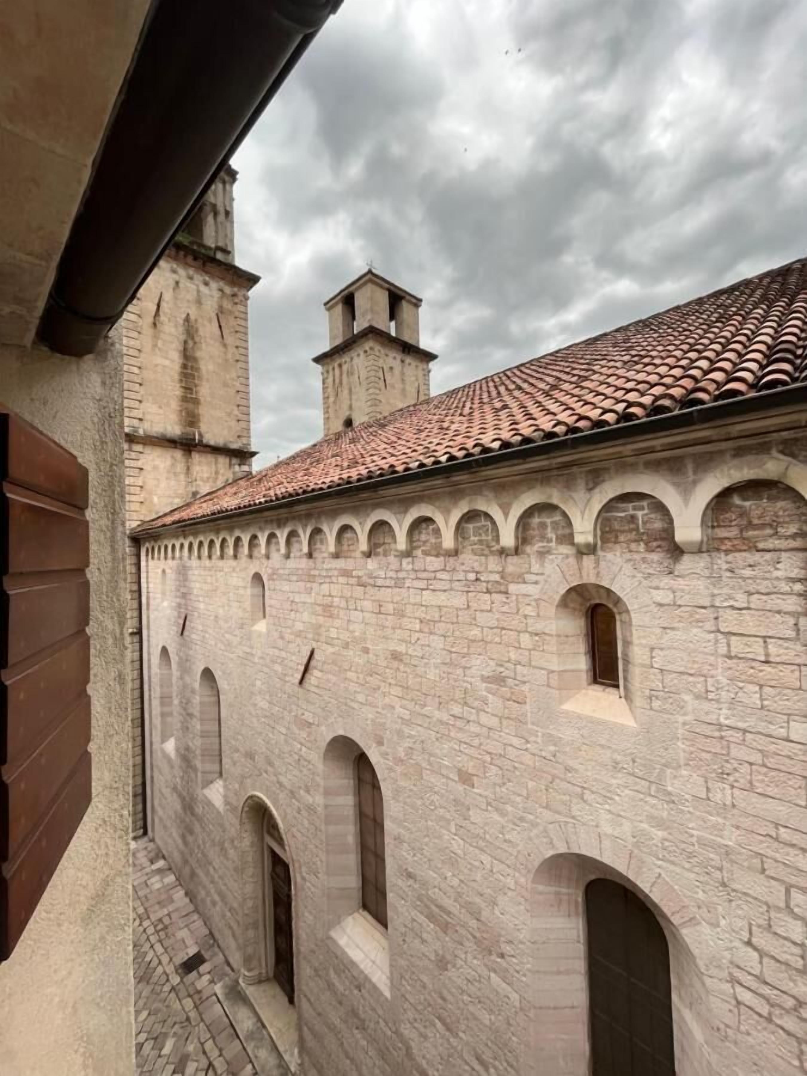A stone building with arched windows and a tiled roof.