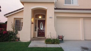 A two-story house with a front entrance, a garage, and a satellite dish on the roof. - Beautiful home, near the Monterey Bay, Carmel & Pebble Beach (Salinas)
