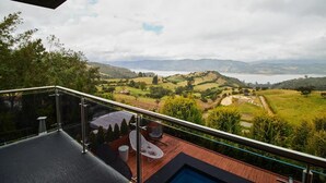 Un balcón con vistas a colinas ondulantes y una masa de agua.