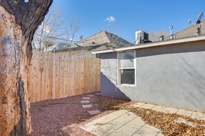 Enjoy a serene outdoor space with a walkway, tree, and a house with a satellite dish and chimney.