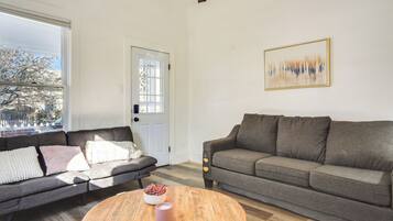 A living room with two sofas, a coffee table, and a door with a window view.