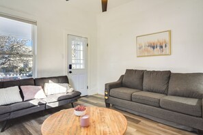 Relax in this stylish living room with a sofa, coffee table, and a beautiful abstract painting.