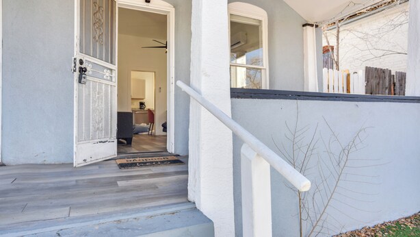 A staircase leading to a porch with a white railing and a wooden fence. - Near UNM & ABQ BioPark: East Dtwn Studio (Albuquerque)