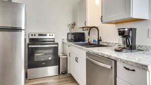 A modern kitchen with stainless steel appliances, a granite countertop, and pendant lighting. - Near UNM & ABQ BioPark: East Dtwn Studio (Albuquerque)