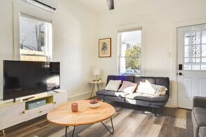Relax in this stylish living room with a flat-screen TV, round coffee table, and comfortable sofa.