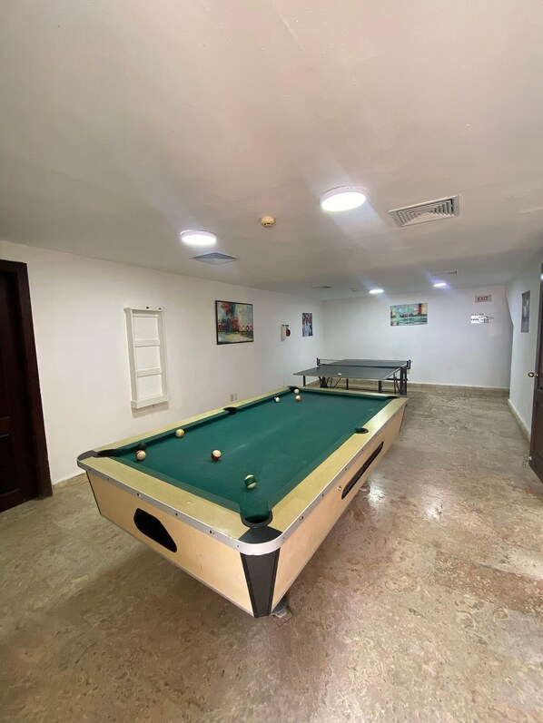 Une table de billard avec des billes, une table de snooker et une porte.