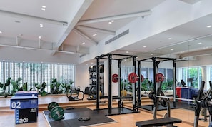 Un gimnasio con equipo de levantamiento de pesas, una banca y una torre de pesas con la etiqueta '1441 FITNESS'.