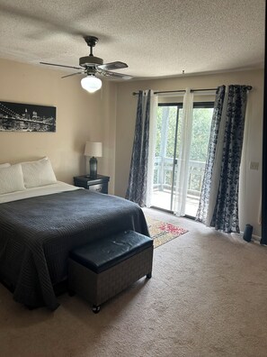 A bedroom with a bed, a nightstand, a lamp, a ceiling fan, and a view of the outdoors through a sliding glass door. - Nurses Heaven

2-bedroom townhome in charming Daleville with WiFi, AC. Come over (Daleville)
