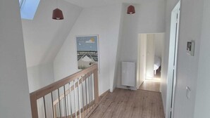 Un hall d’entrée spacieux, doté d’un plancher en bois, d’un plafond en pente et d’une lucarne.