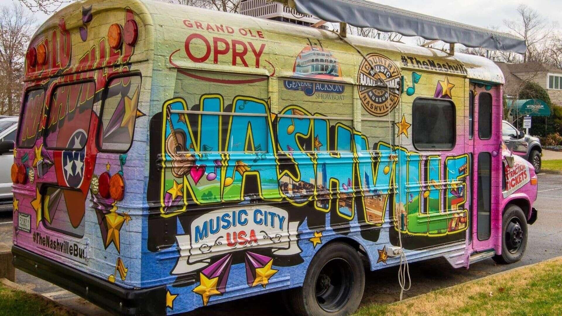A colorful bus with "Nashville Music City USA" and "Grand Ole Opry" graphics, parked on a street.