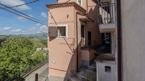 Un bâtiment à deux étages doté d’un balcon, d’une petite fenêtre et d’un escalier menant à l’étage supérieur.