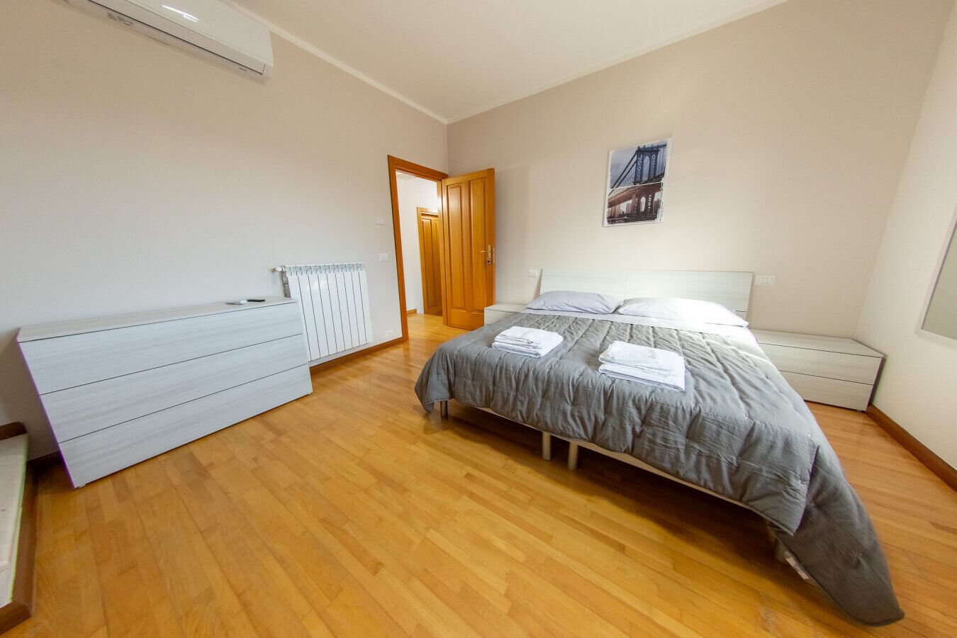 Une chambre à coucher avec un lit, une commode et un radiateur.
