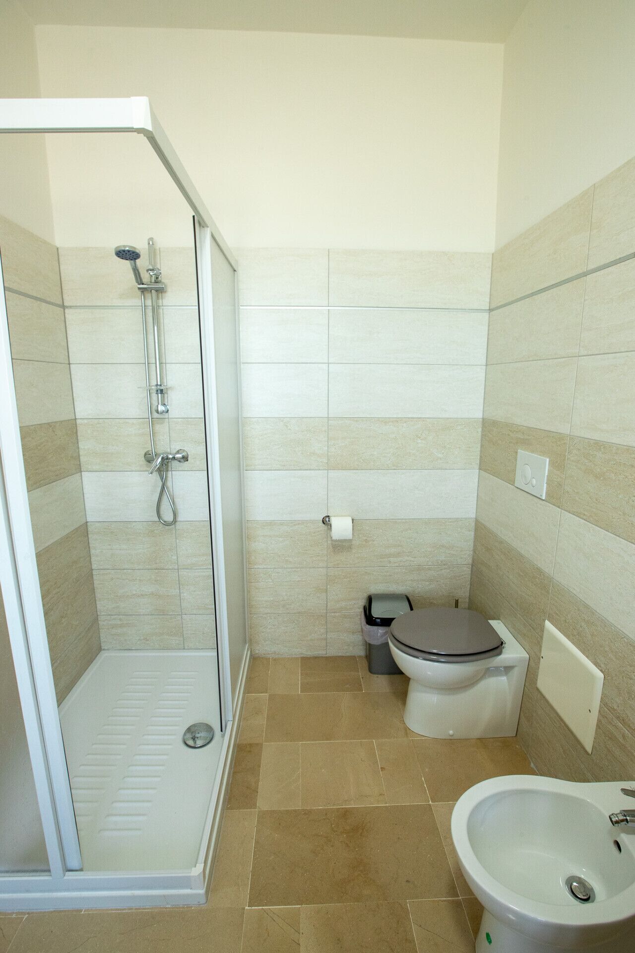 Une salle de bain moderne avec une douche à parois de verre, des toilettes et un lavabo.