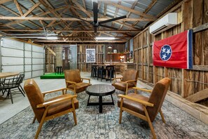 Ein rustikaler Innenraum mit Holzwänden, einer Flagge, einer Bar und Sitzgelegenheiten.