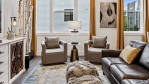 A modern living room with a sofa, two armchairs, a coffee table, and a rug. - View of the City, Rooftop Patio, Games and More! (Nashville)