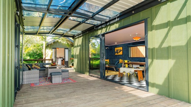 A covered outdoor area with a patio, seating, and a view of the outdoors.