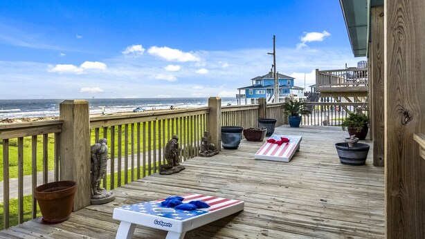 A wooden deck with a view of the ocean, a GoSports table, and potted plants. - Ocean View~Elevator~PetFriendly~Games~Beach Access (Bolivar Peninsula)