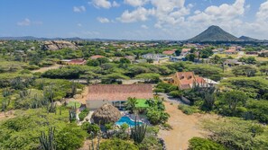 A resort with a pool, surrounded by greenery and a mountain in the background. - Cunucu di Nana - Cottage in the countryside (Paradera)