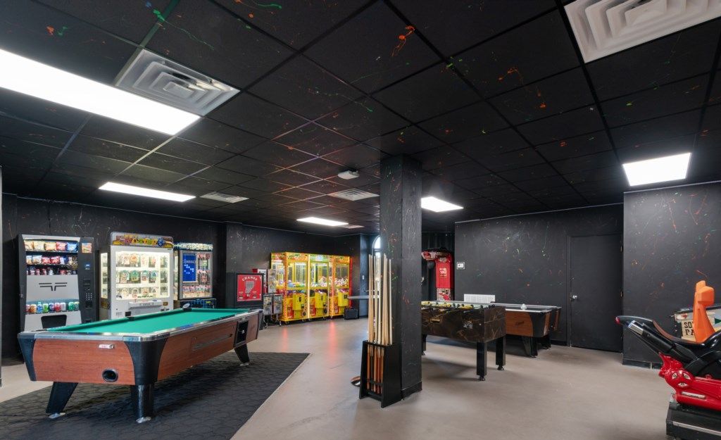 A recreational room with pool tables, foosball, and arcade games.