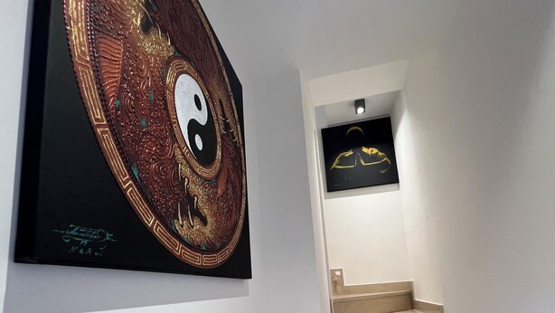 A staircase with a framed artwork of a yin-yang symbol on the wall. - Relax by the Sea – Cozy 2-Bedroom Apartment with Terrace in Campomarino lido (Campomarino)
