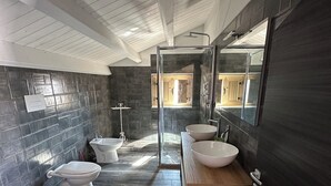 A modern bathroom with a shower, toilet, and sink, featuring dark wood flooring and a large mirror. - Relax by the Sea – Cozy 2-Bedroom Apartment with Terrace in Campomarino lido (Campomarino)