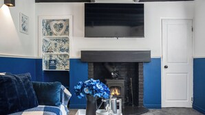 A living room with a fireplace, a sofa, a coffee table with a tray, and decorative items. - 2 bedroom accommodation in Staithes (Staithes)
