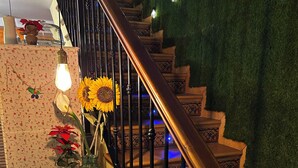 A staircase with a wooden handrail and a green wall. - THE WAY HOTEL & SUITES (Molinaseca)