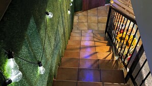 A staircase with artificial grass walls, light fixtures, and a railing. - THE WAY HOTEL & SUITES (Molinaseca)