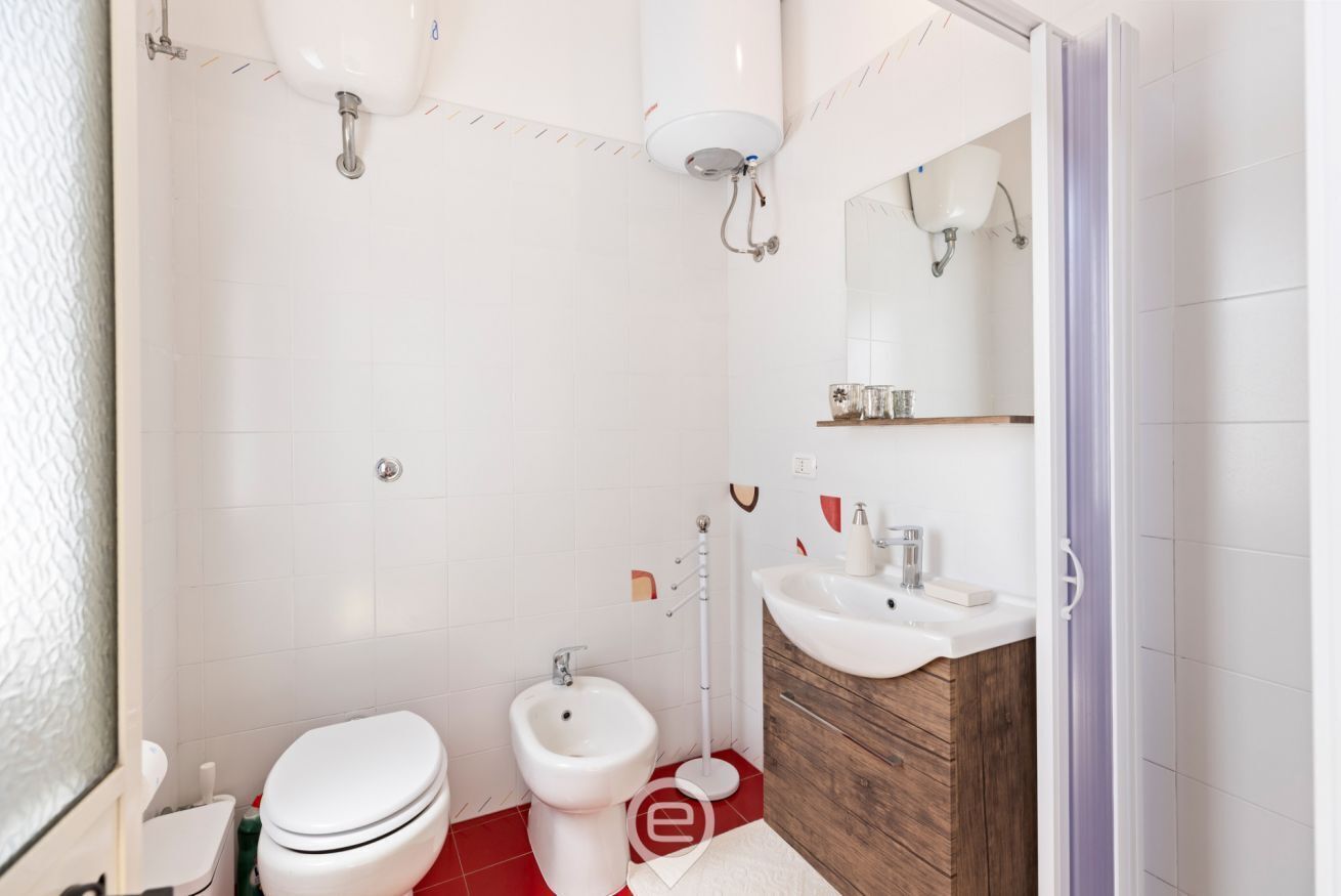 A modern bathroom with a toilet, bidet, and sink.